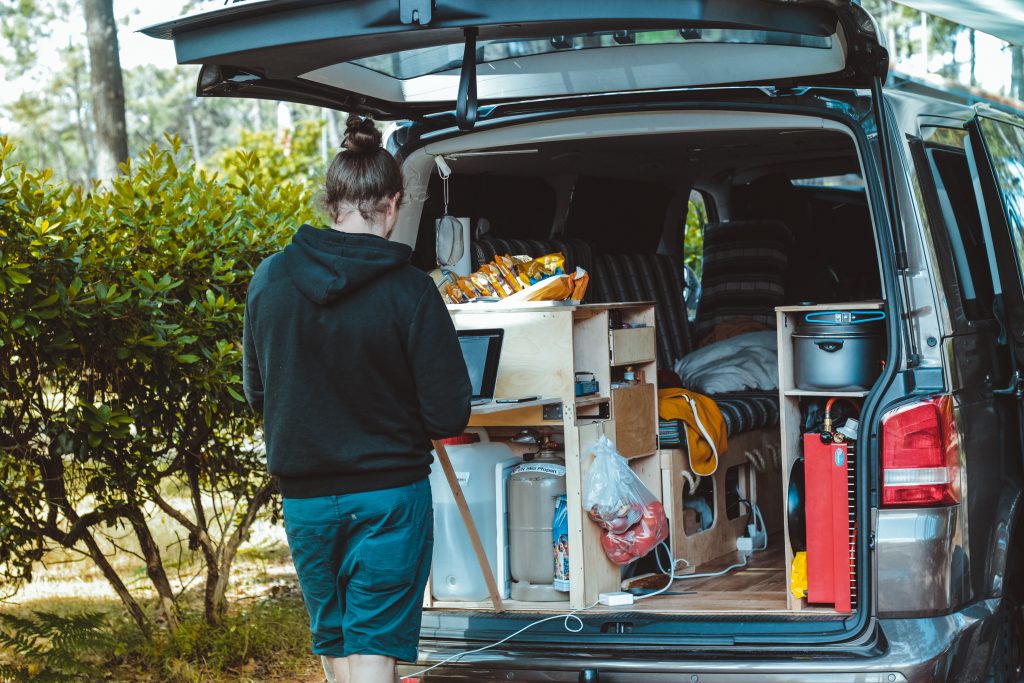 Girl in the back of stocked camper van.